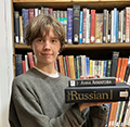 female in front of bookshelves holding Russian books